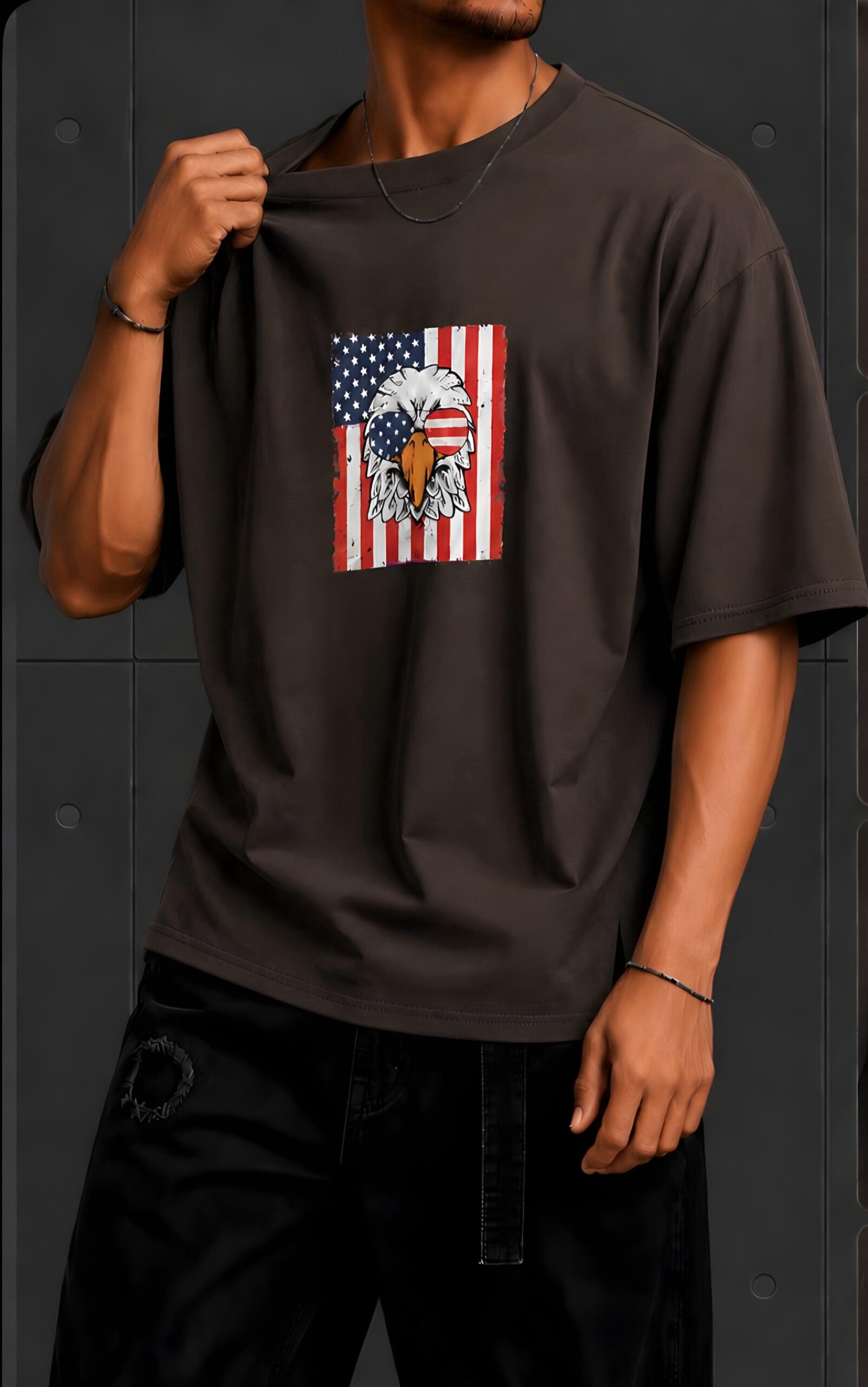 American Eagle Graphic Oversized T-Shirt – Dark Brown Dark brown oversized T-shirt featuring an American eagle and flag graphic on the front, styled with black pants.