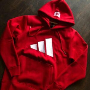 Red premium hoodie with bold white graphic, drawstring hood and kangaroo pocket displayed on a dark wooden surface.