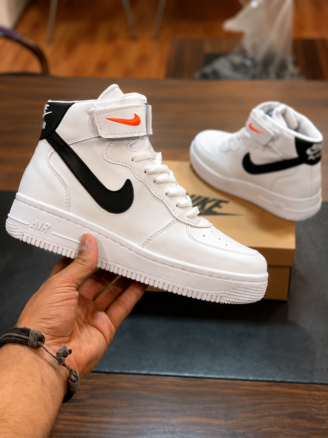 White Black Red High-Top Sneaker White and black high-top sneaker with red logo accent